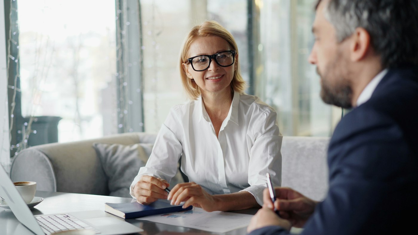 Insurance broker going over a policy with a client in [Town]